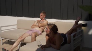 Çift kanepede oturuyor ve televizyon izliyor..