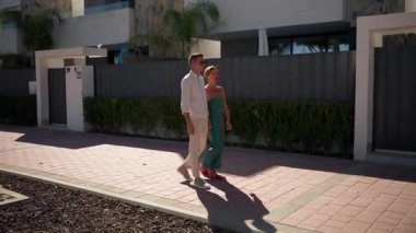 Mutlu çift güneşli bir günde parkta yürüyor..