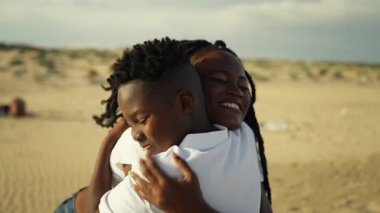 Anne ve oğlu sahilde yürüyor.