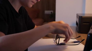 a boy in the office is doing the homework.