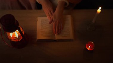 Karanlıkta kitap okuyan kadın.