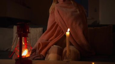 Beyaz cüppeli kız elinde mumla yatakta kameraya bakıyor..