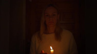Elinde yanan bir mum tutan kadın. Yaklaş.