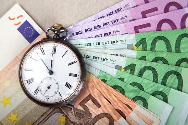 时间和金钱的概念形象。欧元纸币与老式手表 免版税图库照片