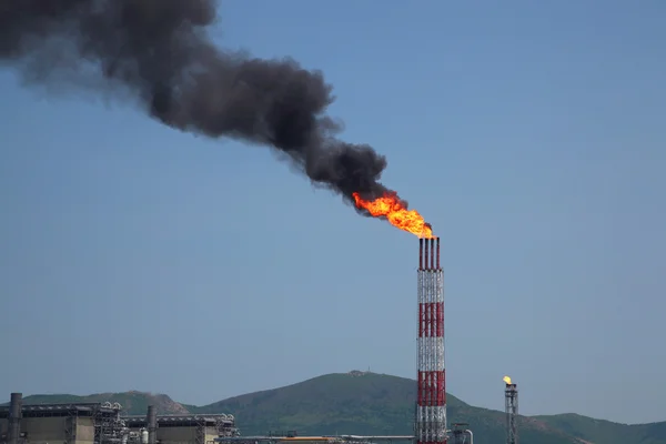 Fakkel van branden begeleidende gas uit raffinaderij stapel tegen bl — Stockfoto