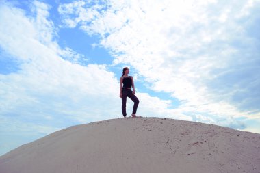 Kumsaldaki atletik bir kızın alt görüntüsü.