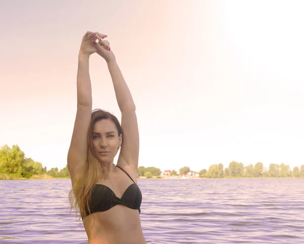 灿烂的阳光照在水中湖面上穿着泳衣的姑娘身上 — 图库照片