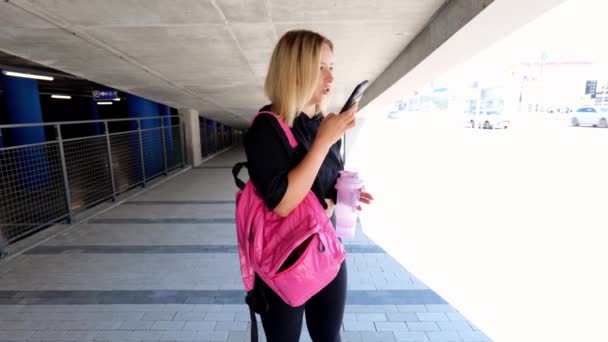 Een Jonge Atletische Vrouw Zwarte Kleren Met Een Rugzak Praat — Stockvideo