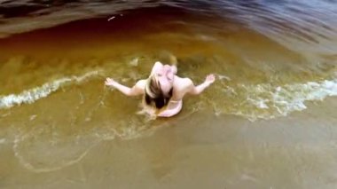 Sahilde, deniz kenarında mayo giymiş bir kadının manzarası. Dinlen ve yüz.