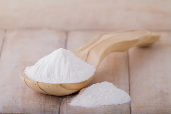 Baking soda in spoon on wooden table — Stock Photo, Image