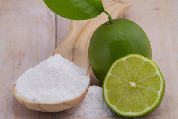 Bakpulver i sked och citron frukt på träbord — Stockfoto