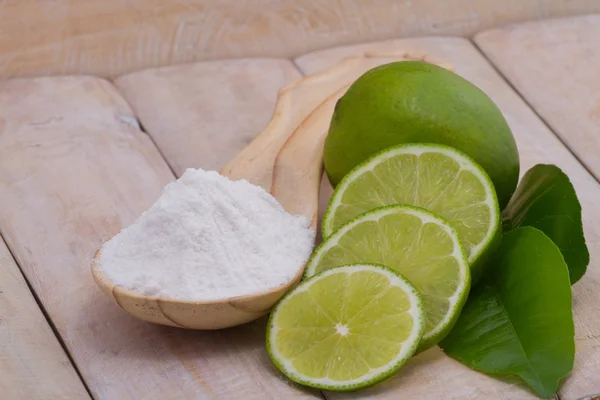 Bicarbonato de sodio en cuchara y fruta de limón en mesa de madera — Foto de Stock