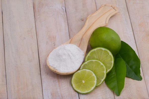 Bakpulver i sked och citron frukt på träbord — Stockfoto