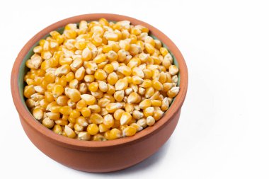 Beyaz arka planda patlamış mısır taneleri olan bir kase