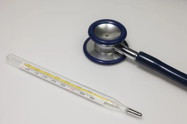 Steteskop ve beyaz arka plan üzerinde termometre