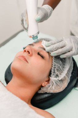 Kapalı kapılar ardında kaplıcadaki kadınlarda yüz temizleme için hidrolik soyma cihazı kullanılıyor.