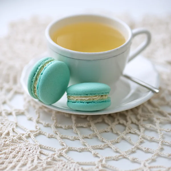Macarrones azules con una taza de té verde —  Fotos de Stock
