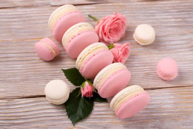 Fransız tatlı macarons ahşap zemin üzerine gül çiçek