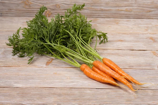 Tahta arka planda taze havuçlar.