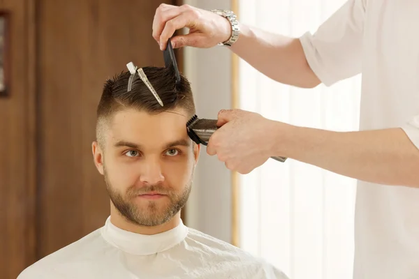 Genç adam otururken ben saç kesimi Kuaför tarafından getting sakallı