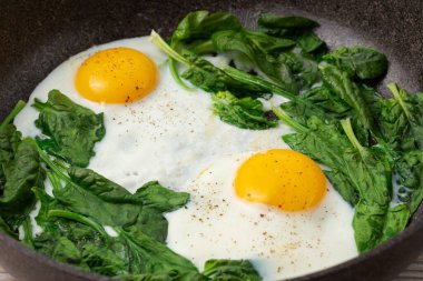 Tava görüntüsünde çırpılmış yumurta ve ıspanak.