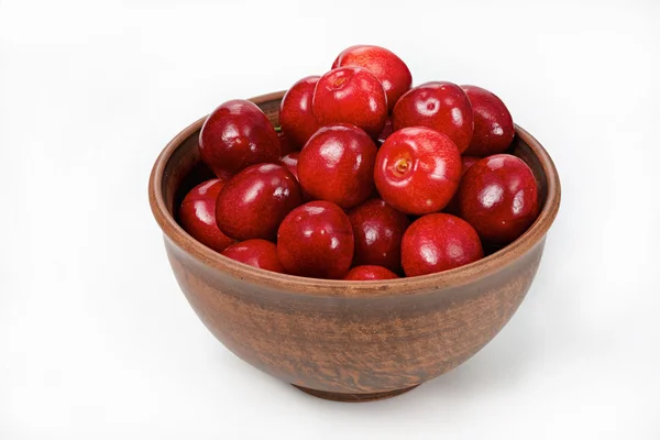 Cerezas rojas en un tazón sobre un fondo blanco — Foto de Stock