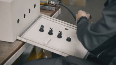 elektrikdolabının kapısına bir sızdırmazlık şeridi takmak Elektrikçi eller yüklemek ve endüstriyel sigorta kutusunda fındık anahtar ekipman sıkın