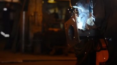 Mühendis Kaynak kıvılcım, duman ve hafif pipes.a sürü Bankası bağlama kaynak. üretim tesisi