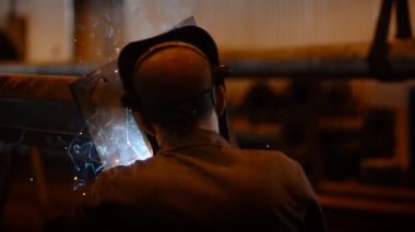 arka görüş kaynak mühendisi bitmiş kaynak yastık altına tüp. Çok parlak kıvılcımlar, duman ve hafif. İnşaat ve imalat