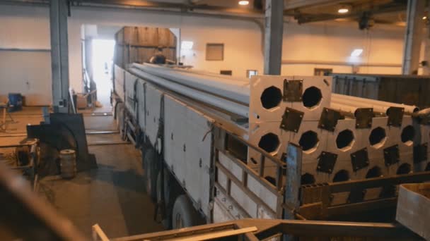 Carga manual de postes largos postes ligeros en un camión de plataforma pesada en la producción de una gran tienda de fábrica — Vídeo de stock