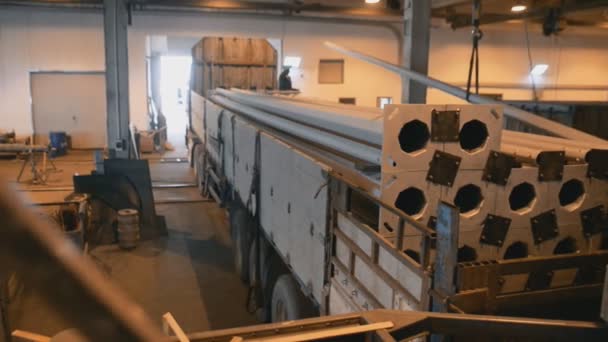 Bir büyük fabrika dükkan üretim için gider uzun direkleri Polonyalılar ağır kamyon yükleme hafif kamyon gemide el ile kaldırma — Stok video