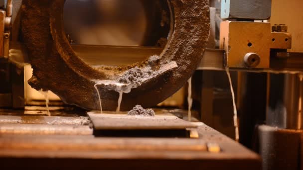 Machine avec une scie large bande métallique utilisant un lubrifiant à base d'huile, et des émulsions. Sciage très lent morceau épais de métal coulé .