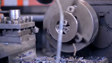 Işleç boyuna freze makinesi ile aktif olarak çalışıyor ve parça tabakası kesmek için bıçak değişmeye devam.