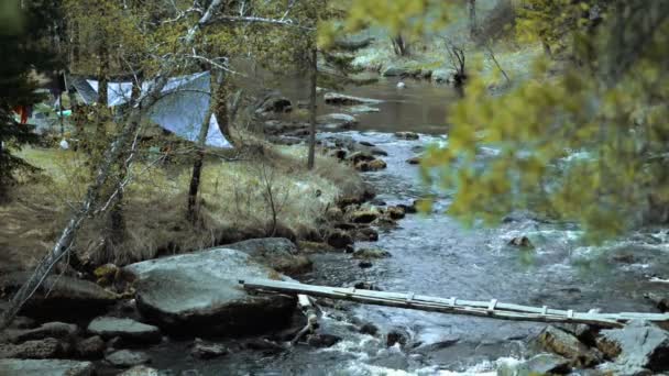 Campamento con turistas en la orilla de un río de montaña . — Vídeos de Stock