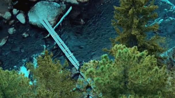 Utazó személyes holmiját, és a kötelek hegymászó filmek az eső a hídon hegyi szibériai folyón. — Stock videók