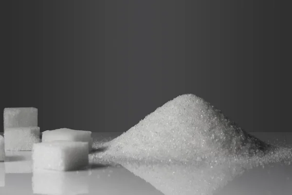 회색 배경에 덩어리 설탕 — 스톡 사진
