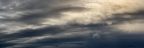 Geniş panoramik manzara arkadaki güneş ışığıyla güzel, dramatik bulutlu gökyüzü