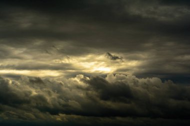 Kümülüs bulutları ve karamsar tasarım için arka ışıklandırması olan karanlık, dramatik gökyüzü