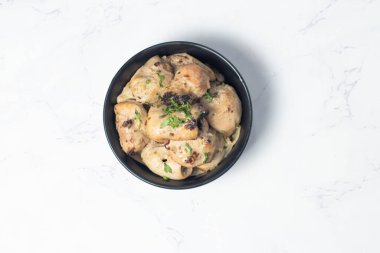 Creamy Malai Tikka Boti in black bowl on marble background top view of Traditional South Asian Grilled Chicken in White Sauce