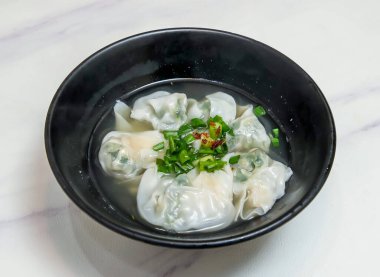 Asya usulü kişniş domuz eti ya da Wonton buharlı Çin Dim Sum 'u mermer arka plan manzaralı siyah klozette.