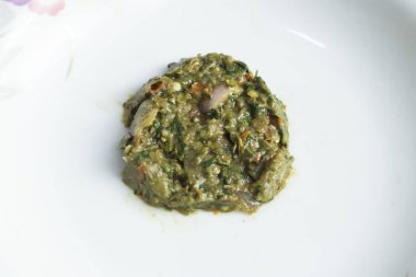 Sutki Bhorta hafif çiçek aksanıyla servis edilen temiz beyaz bir tabakta patlıcan sosu hazırladı.