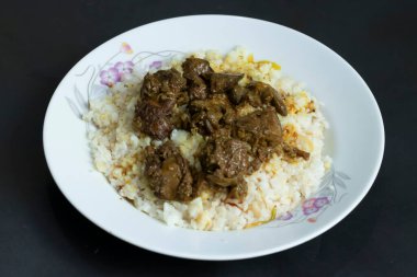 Kolija Polao haşlanmış ciğer ve sakatat yumuşak beyaz pirinç üzerinde sunuluyordu.