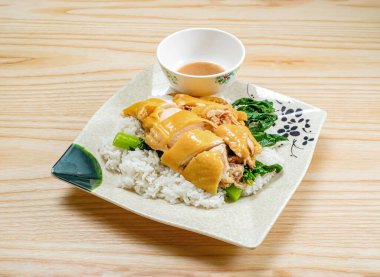 Lezzetli tuzlu fırında pişmiş Hainanese tavuğu taze yeşillik ve lezzetli sos ile servis edilir, yemek blogları ve menüler için mükemmeldir.