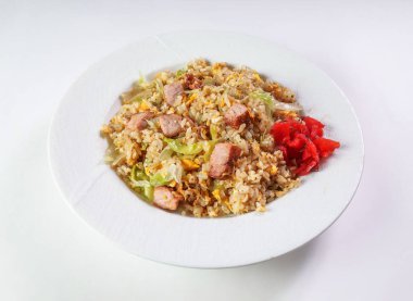 Lezzetli kızarmış domuz pirinci, lahana ve zencefilli beyaz tabakta öğle veya akşam yemeği için servis edilmeye hazır.