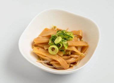 Menma bambu salatası taze soğan ve sağlıklı beslenmek için filizlenen modern beyaz bir kasede salatanın tadını çıkarmaya hazır.