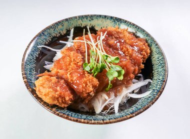 Lezzetli soslu Japon Tonkatsu erik pirzolası ve taze lahanalar güzel bir kasede yenmeye hazır.