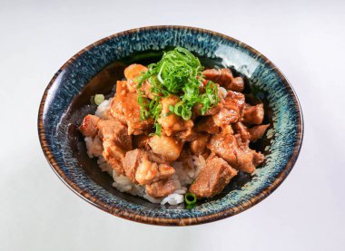 Lezzetli baharatlı domuz pirinçli pilav kasesi üzerinde taze soğanlar basit, lezzetli ve lezzetli bir yemek için hazır.