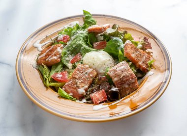 Taze yeşillik, domates ve kremalı salata ile lezzetli somon balığı salatası dikkatli yemek için canlı ve sağlıklı bir öğle yemeği seçeneği oluşturur.