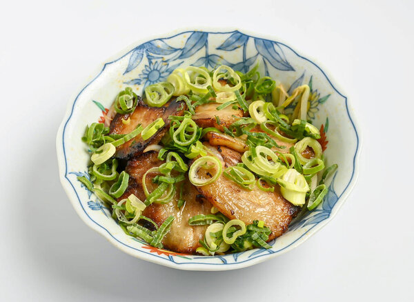 Delicious char siu roast pork belly with fresh scallions served in beautiful ceramic bowl ready to eat anytime for lunch or dinner