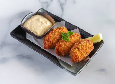 Soslu kızarmış Japon istiridyeleri bir restoranda lezzetli deniz ürünlerine düşkünlük sunuyorlar.